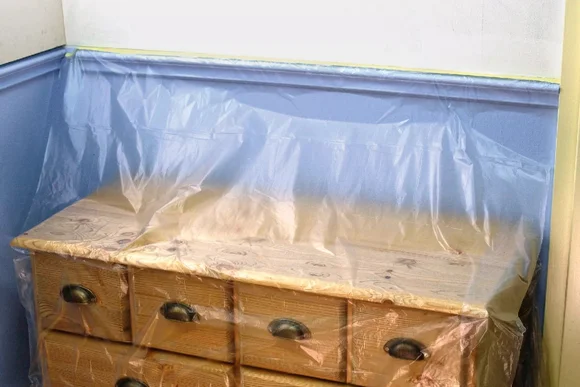 Abgedeckte Kommode mit Folie